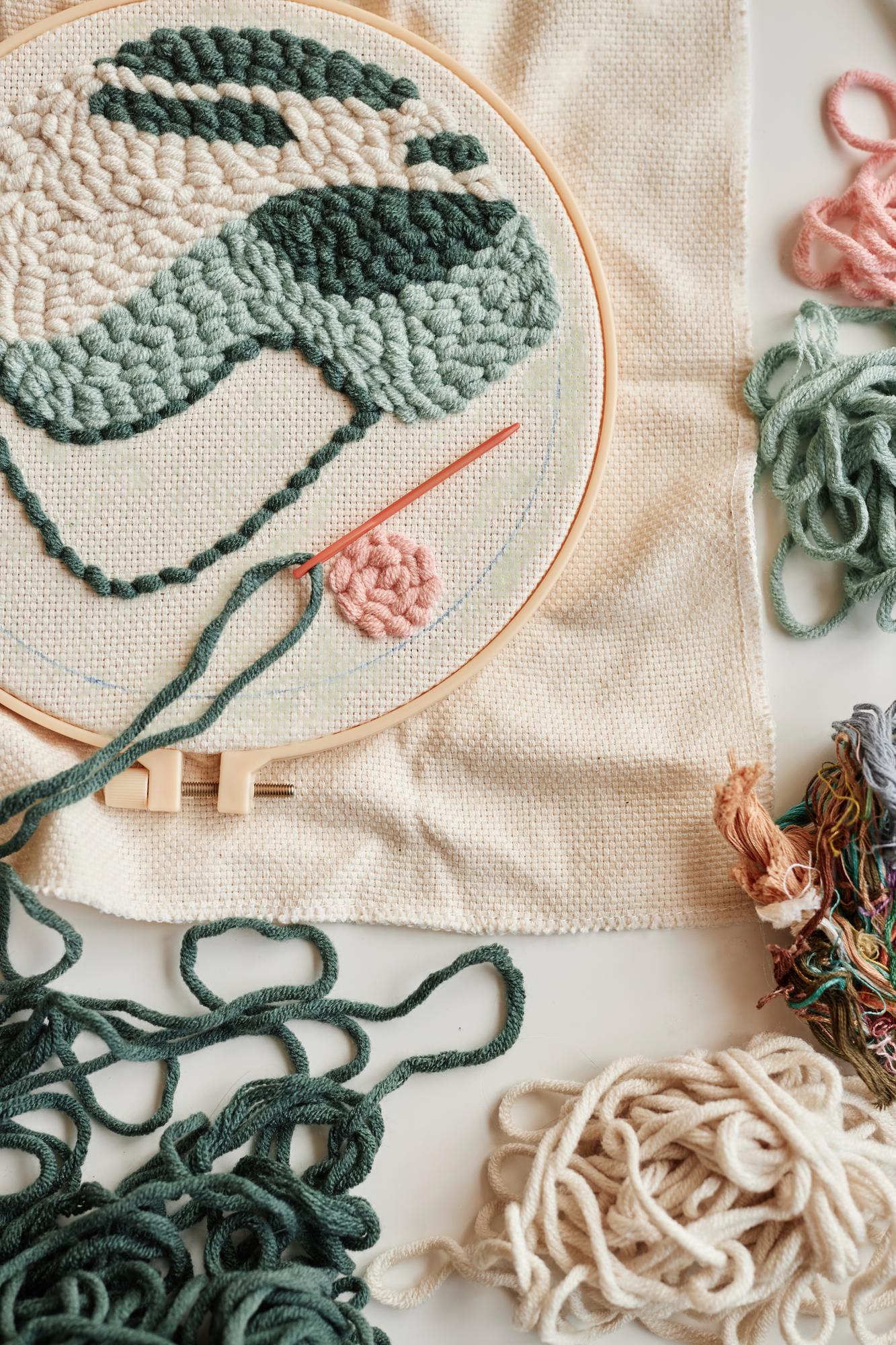 Close-up of hand embroidery on linen with pastel threads